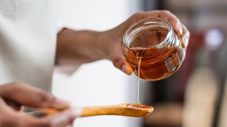 Pouring honey onto spoon