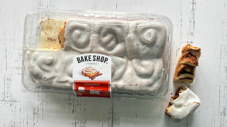Bake Shop cinnamon rolls and container on a white surface