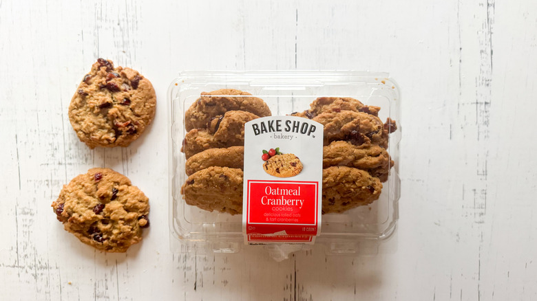 Oatmeal cranberry cookies and container on a white board
