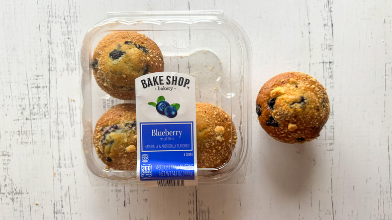 Blueberry muffins and container on a white board