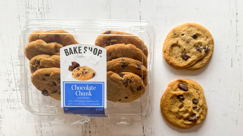 Chocolate chunk cookies and container on a white board