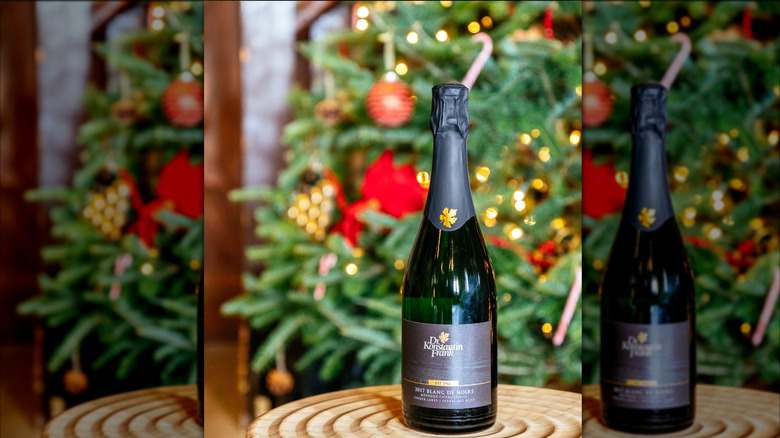 sparkling wine bottle with christmas tree in background