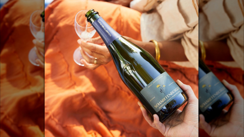 pouring bottle of sparkling wine into glass