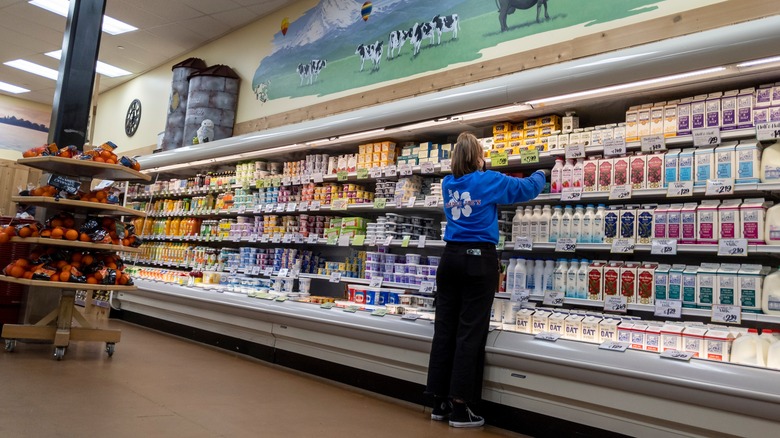 Grocery employee stocking dairy