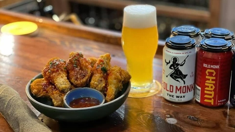 Pint of beer and wings on a wooden bar