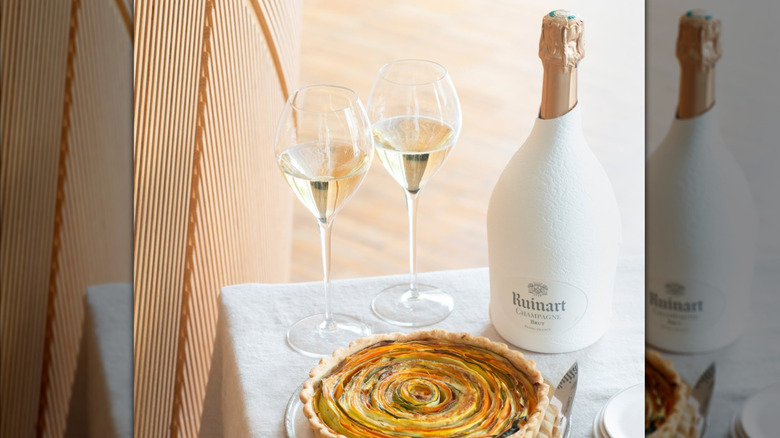 bottle of chamapagne with white casing and two glasses with vegetable tart