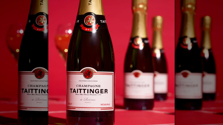 champagne bottles lined up against a red background