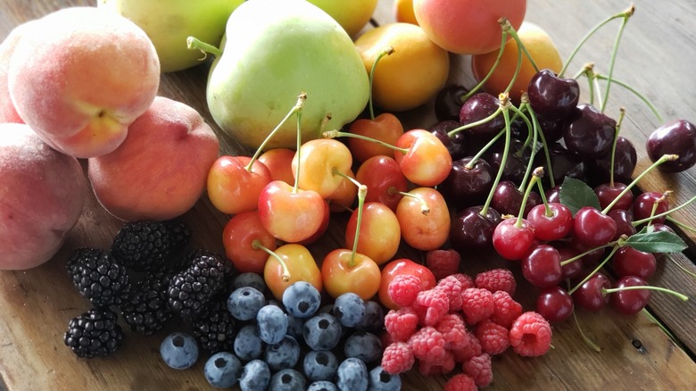 Berries, cherries apples on table