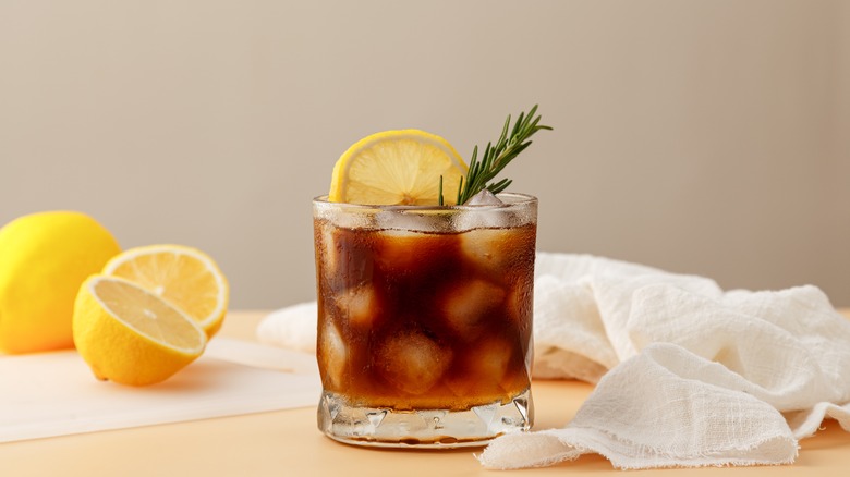 Iced tea in a glass with lemon and rosemary