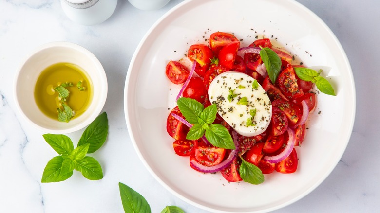 Caprese salad with olive oil, basil, and red onion