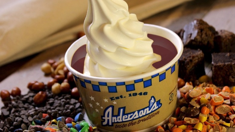 cup of custard surrounded by various toppings 