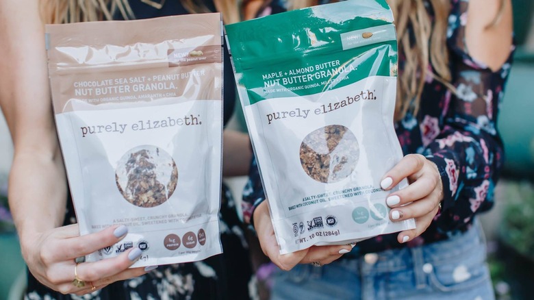 hands holding purely elizabeth granola bags 