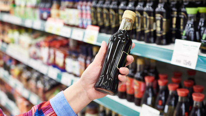 hand holding bottle of soy sauce