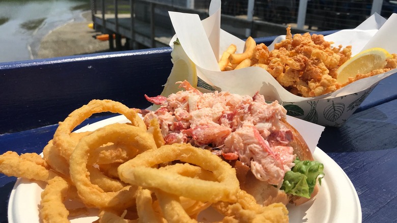 Lobster roll served with onion rings