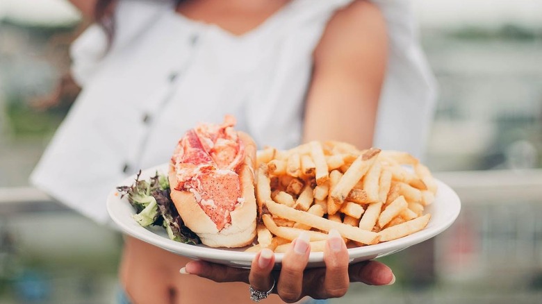 A woman serving a lobster roll