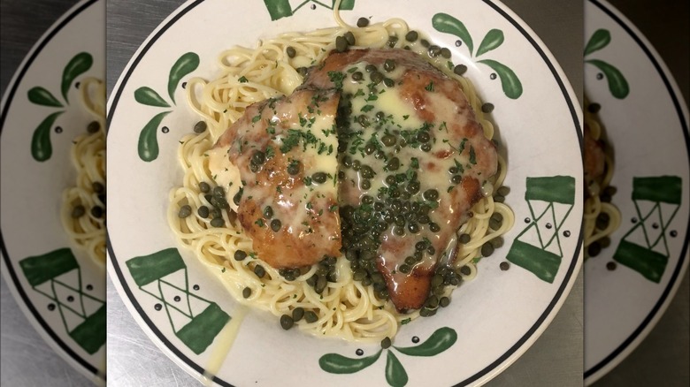 Plate of pasta with capers and breaded chicken