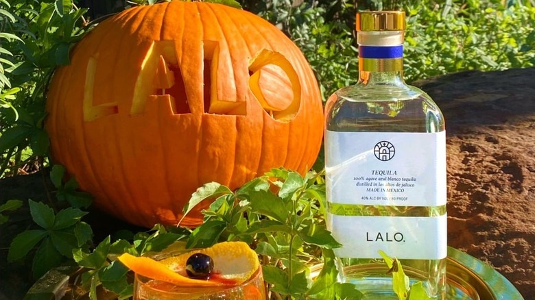 Tequila bottle next to pumpkin