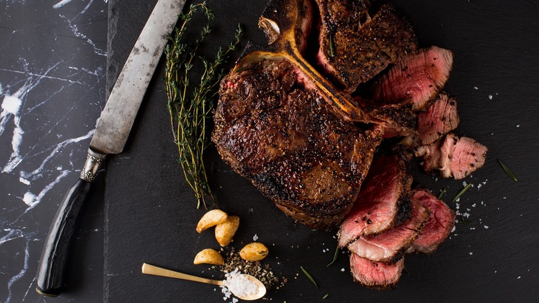 Steak with rosemary and garlic on black slate