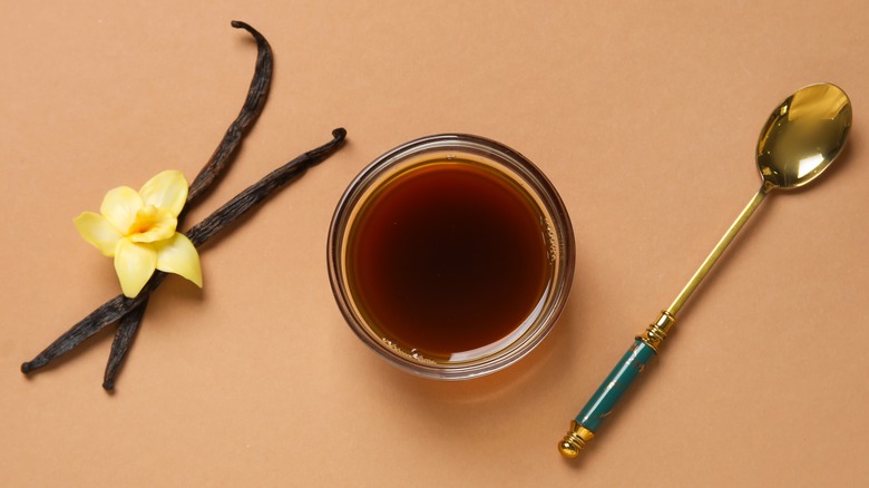 Vanilla extract in cup, spoon