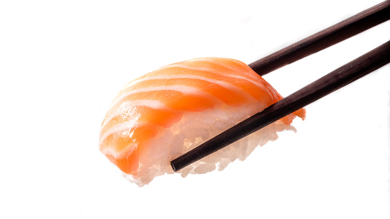 salmon nigiri in chopsticks