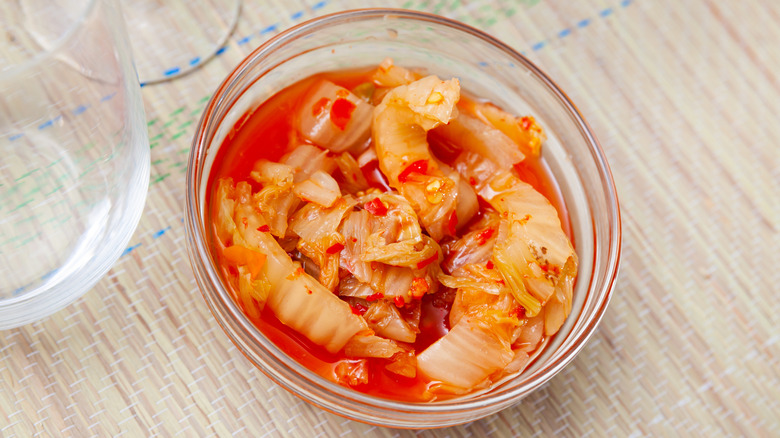 Kimchi with brine in small glass bowl