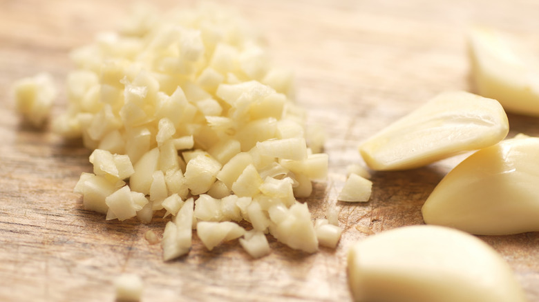 Minced garlic on wooden cutting board