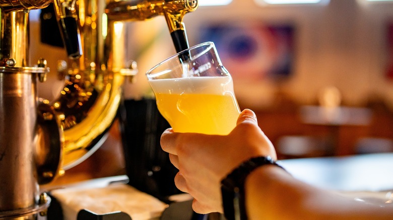 pouring beer from tap into a pint glass