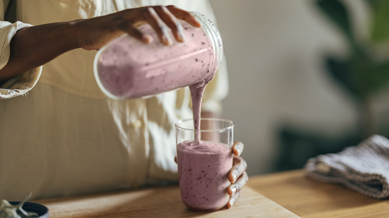 person pouring a smoothie 