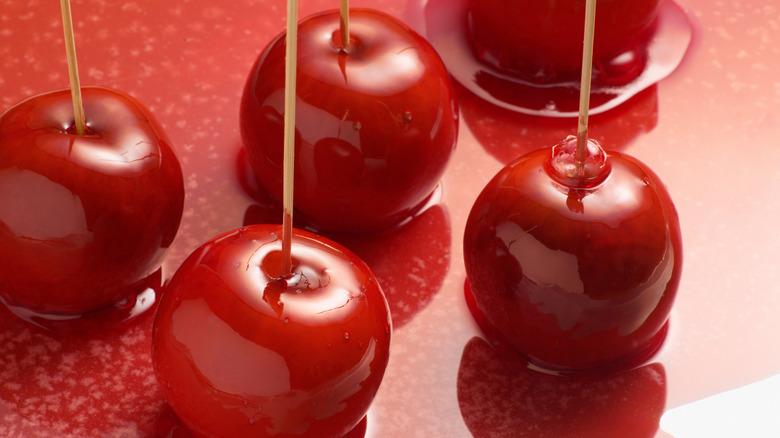 Red candy apples on a shiny red surface