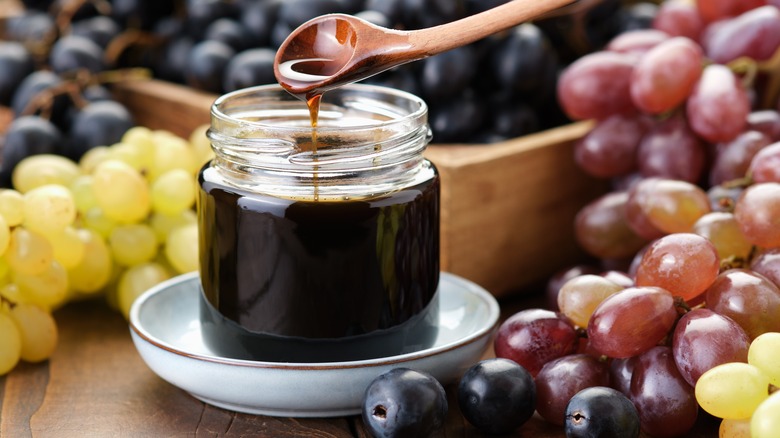 Grapes surrounding jar of syrup