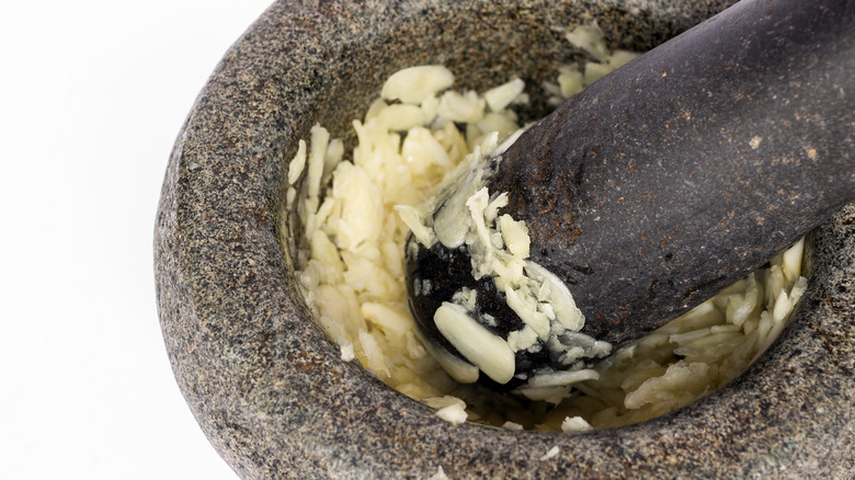 Pestle crushing garlic