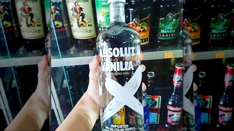 Hand holding Absolut Vanilia bottle