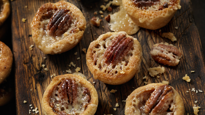 Pecan tarts on wooden board