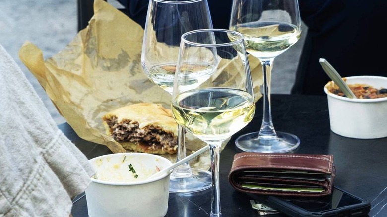 Three wine glasses on a table with a burger at Cana Wine Bar