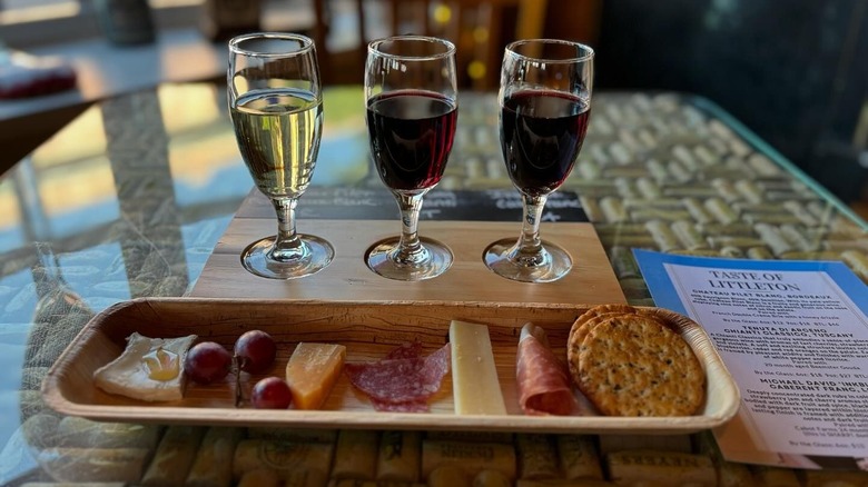 Three wine glasses behind fruit, meat, and cheese board at Kate's Wine Bars