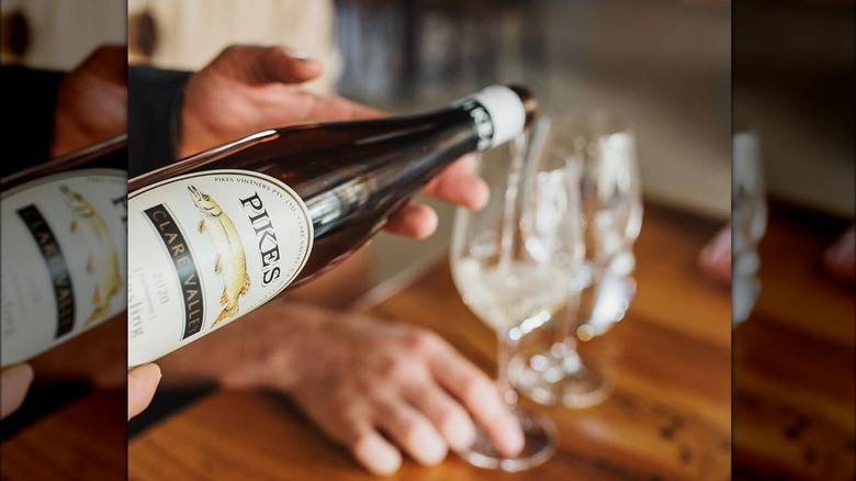 person pouring riesling wine