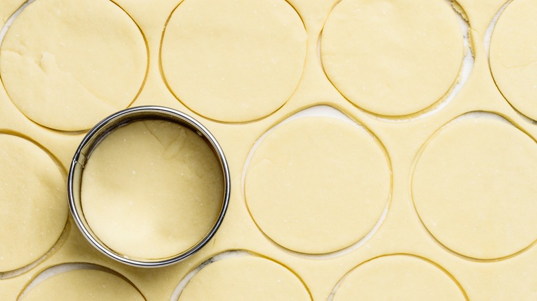 Cutting biscuit dough with cutter 