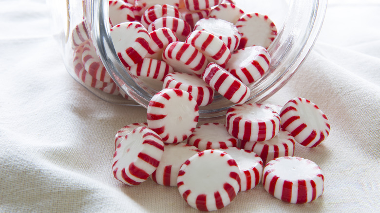 Peppermint candies spilling from jar