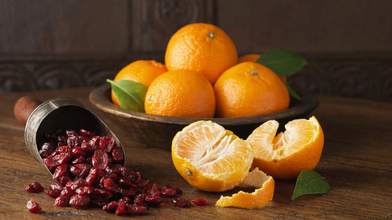 cranberries and oranges on wooden table