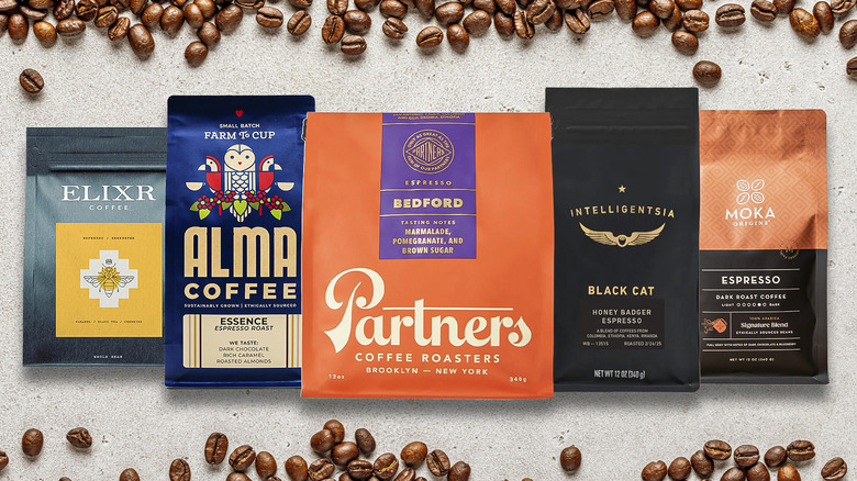 5 bags of coffee with coffee beans on grey background