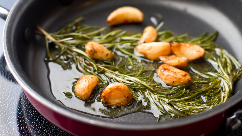 Cooking garlic cloves in pan