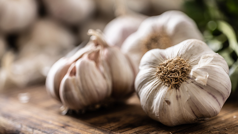 Unpeeled garlic kept on a wooden counter