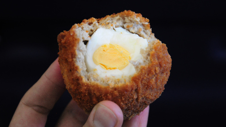 Scotch egg held aloft