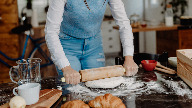 Woman rolls out dough 