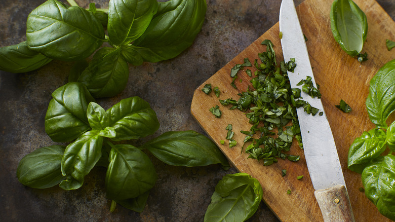 Fresh basil leaves and chopped basil on cutting board