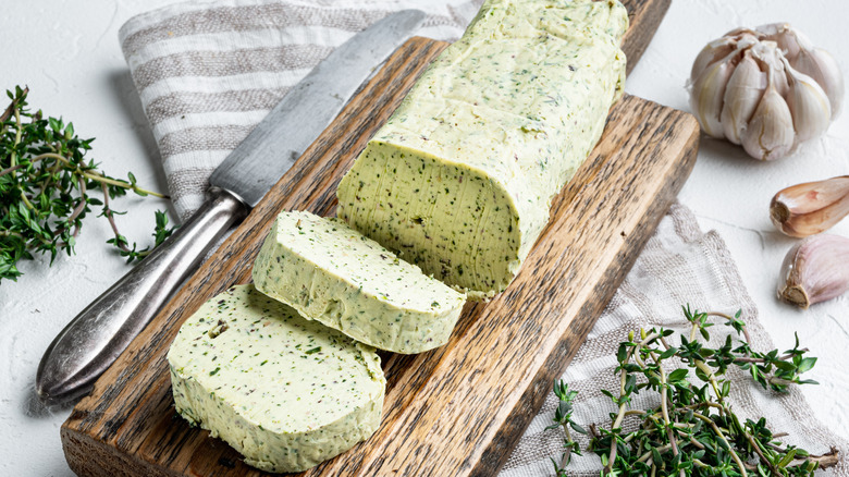 Dairy green butter with herbs set, on white stone surface