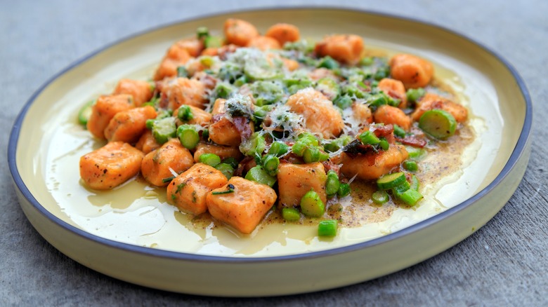 a plate of sweet potato gnocchi with asparagus 