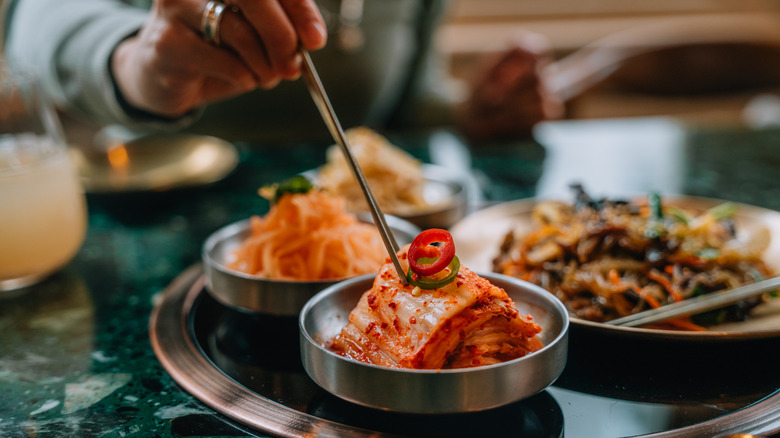 Woman eating kimchi with chopsticks