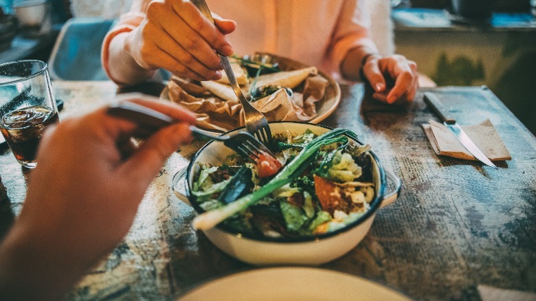 Two diners sharing a salad