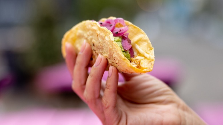 Woman's hand holding taco